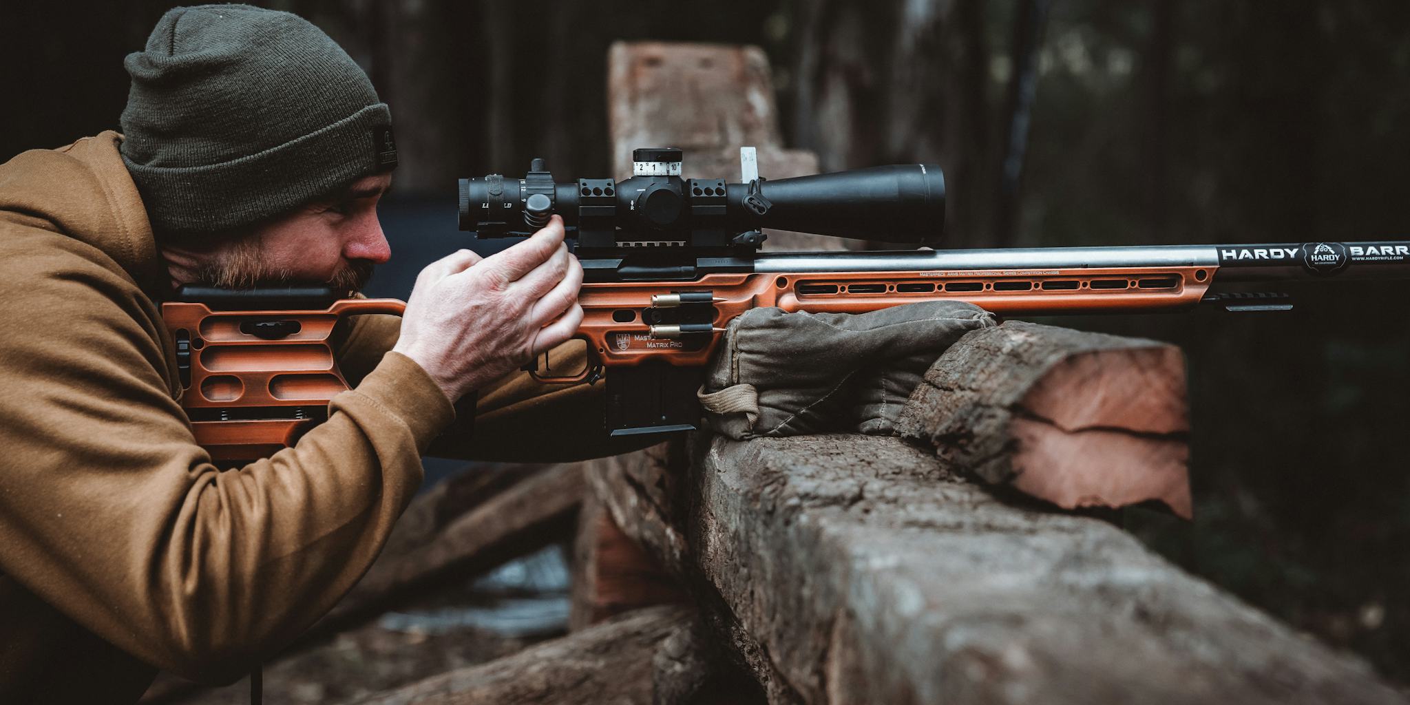 A man using a precision rifle setup with Hardy Barrell